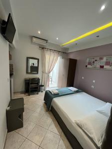 a bedroom with a large bed and a television at Grecian Sea in Limenaria