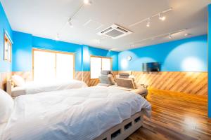 a bedroom with two beds and a blue wall at Hotel Beach-House in Otsu