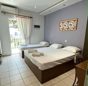 two beds in a room with a window at Grecian Sea in Limenaria