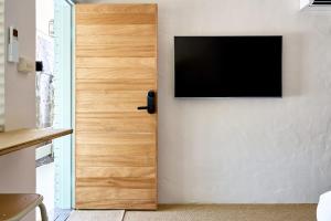 a door with a television on a wall at Chalet Motel Brunswick Heads in Brunswick Heads