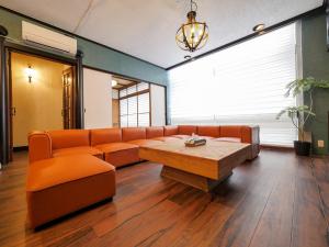 ein Wartezimmer mit Sofa und Tisch in der Unterkunft E E House in Numazu