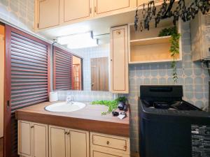 eine kleine Küche mit Spüle und Arbeitsplatte in der Unterkunft E E House in Numazu + 90 Fotos