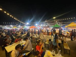 a crowd of people sitting at tables at a market at night at Jr - House 2 34-103 in Ban Talat Rangsit