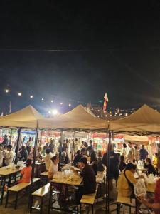 a group of people sitting at tables under tents at Jr - House 2 34-103 in Ban Talat Rangsit