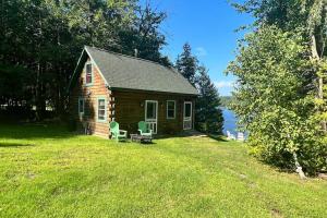a small cabin with a table and chairs in the grass at Lenas in Waterville