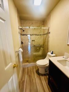 a bathroom with a shower and a toilet and a sink at San Clemente Surf Inn in San Clemente