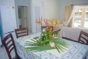 a dining room table with a vase of flowers on it at MOEROA VILLAS in Avatiu