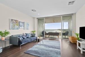 a living room with a couch and a tv at Meander - Port Noarlunga South - C21 SouthCoast Holidays in Port Noarlunga South +16 photos