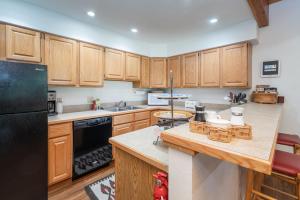 a kitchen with wooden cabinets and a black refrigerator at Riverside Condos D02 condo in Telluride