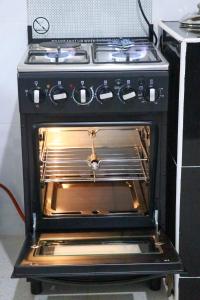 an oven with its door open in a kitchen at M's BNB in Bungoma