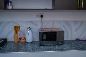 a microwave sitting on a counter in a kitchen at M's BNB in Bungoma +14 photos