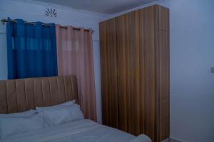 a bedroom with a bed and a large wooden closet at M's BNB in Bungoma