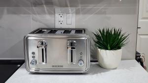 a toaster sitting on a kitchen counter with a potted plant at TNC Stays Luxurious Modern Suite Seton Calgary South in Calgary