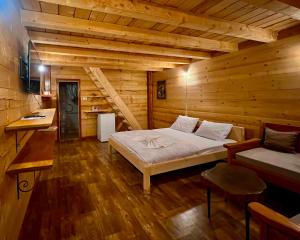 a bedroom with a bed in a wooden cabin at Lagano Mountain Retreat - Via Ferrata & Restaurant in Gusinje
