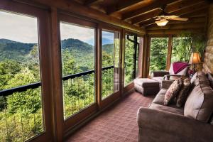 a screened in porch with couches and windows at Alpine Vista in Lenoir