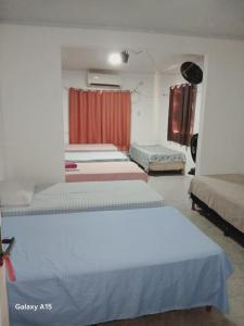 a group of four beds in a room at Pousada central Russana in Russas +56 photos
