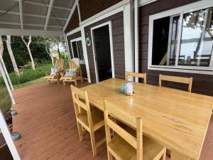 a wooden table and chairs on a screened in porch at Aore Shores Beachfront Bungalow in Aore Island