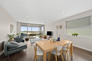 a living room with a table and a couch at Meander - Port Noarlunga South - C21 SouthCoast Holidays in Port Noarlunga South