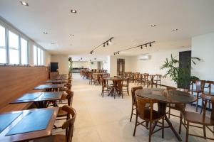 a row of tables and chairs in a restaurant at Victory Suites in Juiz de Fora