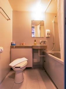 a bathroom with a toilet and a sink and a mirror at Shakespeare Hotel in Hakuba +34 photos