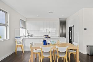 a kitchen and dining room with a table and chairs at Meander - Port Noarlunga South - C21 SouthCoast Holidays in Port Noarlunga South