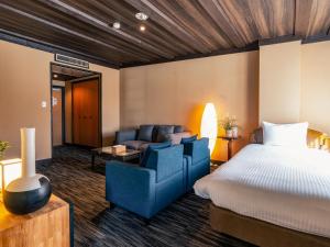 a hotel room with a bed and a couch at Shakespeare Hotel in Hakuba