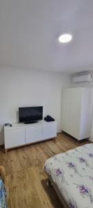 a bedroom with a bed and a tv on a white cabinet at Elena Haus in Cluj-Napoca
