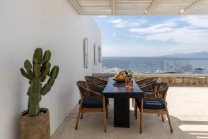 a dining room with a table and chairs and a cactus at Casa Kiku Mykonos in Mikonos