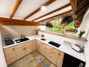 a kitchen with wooden cabinets and a window at Jala Villas Lances Right HTs Mentawai in Katiet
