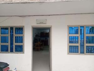 a white building with two windows and a door at Hospedaje Meriland in Guayabal