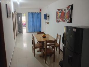 a dining room with a table and chairs and a refrigerator at Hospedaje Meriland in Guayabal