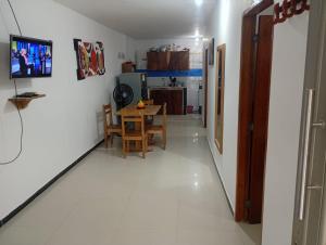 a kitchen and dining room with a table and a television at Hospedaje Meriland in Guayabal
