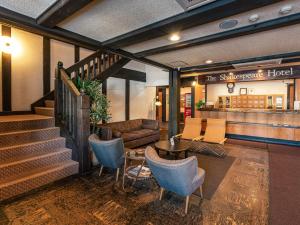 a lobby with a couch and a table and chairs at Shakespeare Hotel in Hakuba