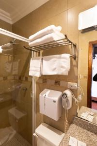 a bathroom with a toilet and a shower and towels at Hotel & Suites El Quijote in Cuenca +245 photos