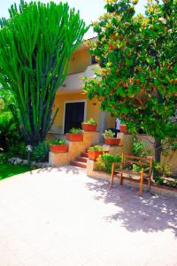 a house with two benches in front of it at Happy Holiday Villa - Pool & Garden in Syracuse +24 photos
