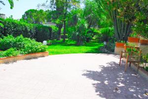 a park with two benches on a brick walkway at Happy Holiday Villa - Pool & Garden in Syracuse