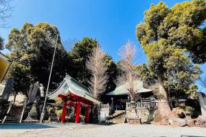 a small red building with trees in the background at Mitte Lodge 健やかな大人達の田舎ホームステイ1日1組限定で駅送迎と3食家庭料理体験付き in Atami