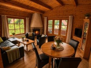 a living room with a table and chairs and a fireplace at Ferienwohnungen Forellengrund Schierke in Schierke