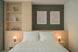 a bedroom with a large white bed with two lamps at TS Apartment in Hanoi