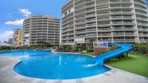 a swimming pool with a slide in front of two tall buildings at Gemini Resort 55 Stunning Ocean Views in Golden Beach +9 photos