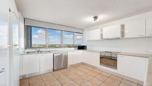 a kitchen with white cabinets and a large window at Gemini Resort 55 Stunning Ocean Views in Golden Beach