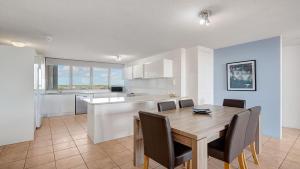 a kitchen and dining room with a wooden table and chairs at Gemini Resort 55 Stunning Ocean Views in Golden Beach