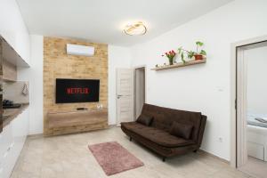 a living room with a couch and a tv at DowntownKate in Debrecen