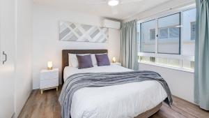 a bedroom with a large bed and a window at Tripcony Quays Unit 11 in Caloundra +4 photos