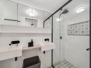 a white bathroom with two sinks and a shower at Aurora Pacific Unit 12 in Caloundra +7 photos