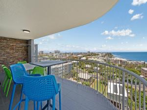 a balcony with a table and chairs and the ocean at Aurora Pacific Unit 12 in Caloundra