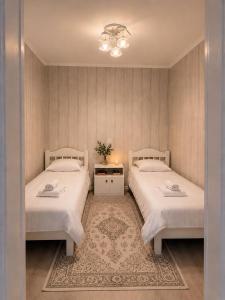 a bedroom with two beds and a table at Green in Bokonbayevo