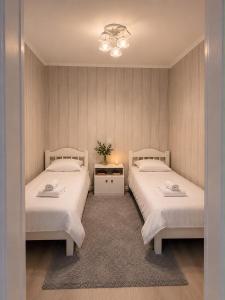 a bedroom with two beds and a table with flowers at Green in Bokonbayevo