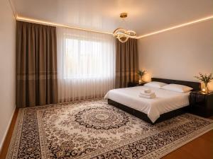 a bedroom with a bed and a large window at Green in Bokonbayevo