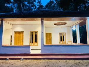 a white house with windows and a porch at Lotus Green Hotel And Restaurant in Arugam Bay +7 photos